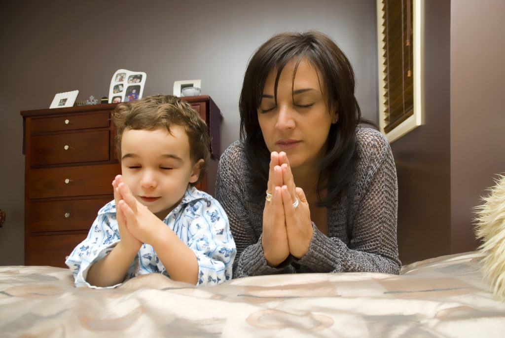 Mom praying with her child